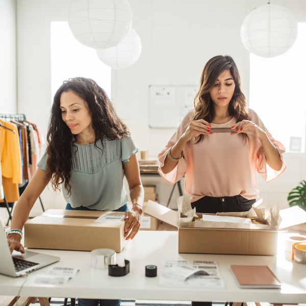 brunette women working and packaging clothing from small business