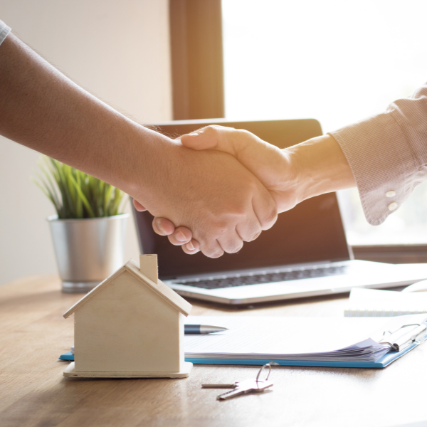 two people handshake over desk